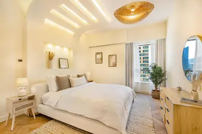 a white bedroom with a large bed and a window at Daniels 2BR at Rimal JBR with Marina View in Dubai