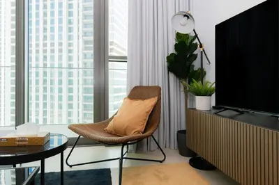 a living room with a chair and a television at Elite Escape - 1 BHK Getaway Dubai Mall Access - 1509 in Dubai
