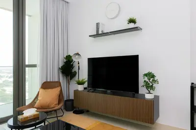 a living room with a television and a chair at Elite Escape - 1 BHK Getaway Dubai Mall Access - 1509 in Dubai