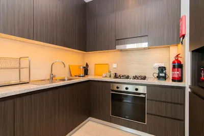 a kitchen with wooden cabinets and a stove and a sink at Elite Escape - 1 BHK Getaway Dubai Mall Access - 1509 in Dubai