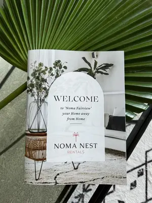 a sign on a table with a vase on it at Noma Fairview - Burj Khalifa view stunning apartment in Business Bay in Dubai