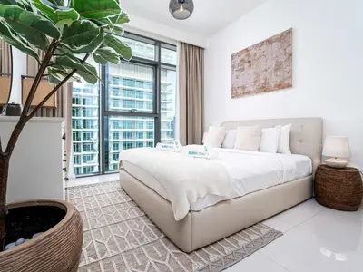 a bedroom with a large bed and a potted plant at Luxury Living in Emaar Beachfront w Private Beach in Dubai