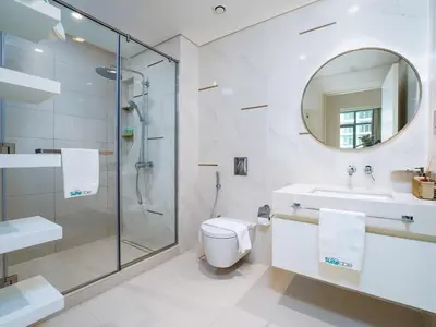 a bathroom with a shower and a toilet and a sink at Luxury Living in Emaar Beachfront w Private Beach in Dubai