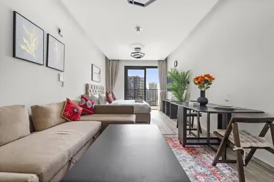 a living room with a couch and a table at Spacious Studio In Prime Location in Dubai