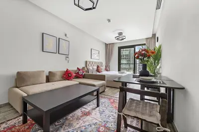 a living room with a couch and a table at Spacious Studio In Prime Location in Dubai