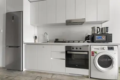 a kitchen with a washing machine and a microwave at Spacious Studio In Prime Location in Dubai