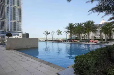 a large swimming pool with palm trees and buildings at Fabulous Canal Views Al Habtoor City in Dubai