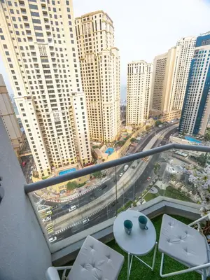 a balcony with a table and chairs and a city at Luxury two bedrooms with Jbr and Marina view apartment in Dubai