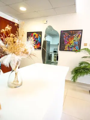 a vase of flowers on a table in a room with paintings at Luxury two bedrooms with Jbr and Marina view apartment in Dubai