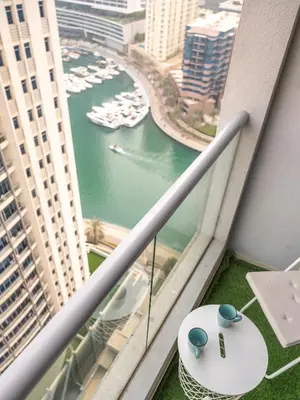 a balcony with a view of a river and boats at Luxury two bedrooms with Jbr and Marina view apartment in Dubai