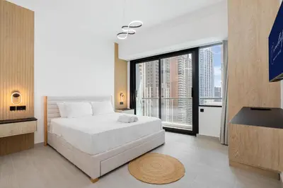 a bedroom with a white bed and a large window at The Luxe Marina Experience - Stylish 2BR with Sweeping Balcony Views for Total Relaxation in Dubai