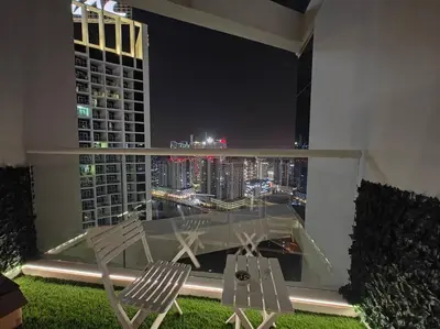a balcony with a view of a city at night at LeModCasa - Modern Chic studio in Dubai
