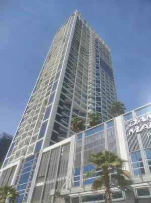 a tall building with palm trees in front of it at LeModCasa - Modern Chic studio in Dubai