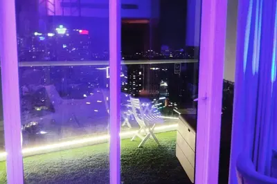 a window with a view of a city at night at LeModCasa - Modern Chic studio in Dubai