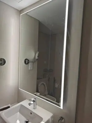 a bathroom mirror with a sink and a toilet at LeModCasa - Modern Chic studio in Dubai