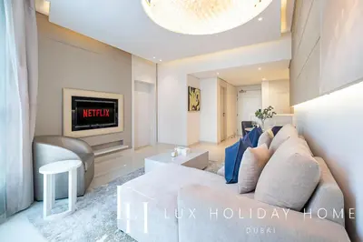 a living room with a couch and a tv at LUX The Voleo Canal View Suite in Dubai