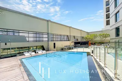a swimming pool in front of a building at LUX The Voleo Canal View Suite in Dubai