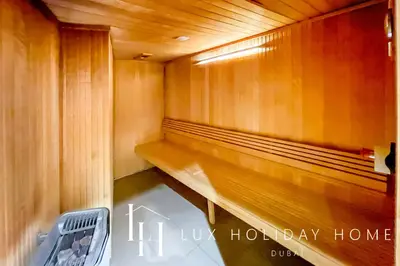 a wooden bench in a sauna with at LUX The Voleo Canal View Suite in Dubai