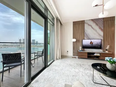 a living room with a tv and a large window at Trophy - 1BR Beachfront Retreat w Lagoon Views in Dubai