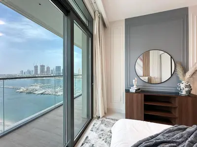 a bedroom with a view of the water at Trophy - 1BR Beachfront Retreat w Lagoon Views in Dubai