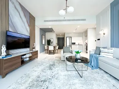 a living room with a couch and a tv at Trophy - 1BR Beachfront Retreat w Lagoon Views in Dubai