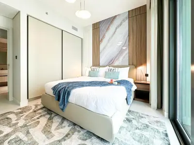 a bedroom with a white bed with a rug at Trophy - 1BR Beachfront Retreat w Lagoon Views in Dubai