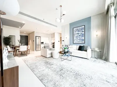 a living room with white furniture and a dining room at Trophy - 1BR Beachfront Retreat w Lagoon Views in Dubai