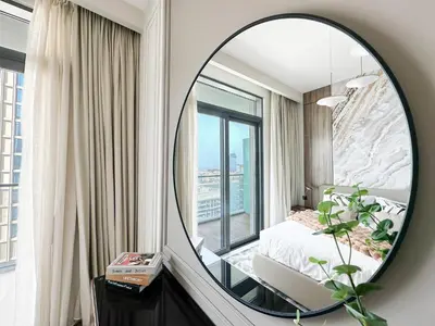 a mirror in a bedroom with a bed and a window at Trophy Luxury 1BDR in Emaar Beach Front with Panoramic Sea Views from the Apartment and Private Beach Access in Dubai