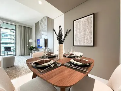 a dining room with a wooden table and chairs at Trophy Luxury 1BDR in Emaar Beach Front with Panoramic Sea Views from the Apartment and Private Beach Access in Dubai