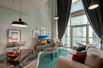 a living room with a couch and a tv at Blueground DIFC marina view pool gym DXB-21 in Dubai