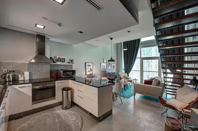 a kitchen with a counter and a living room at Blueground DIFC marina view pool gym DXB-21 in Dubai