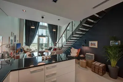 a kitchen with a staircase and a living room at Blueground DIFC marina view pool gym DXB-21 in Dubai