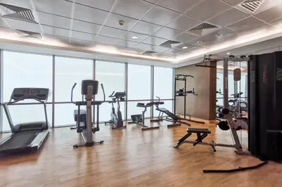 a gym with treadmills and exercise equipment in a building at Blueground DIFC marina view pool gym DXB-21 in Dubai
