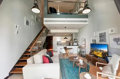a living room with a white couch and a table at Blueground DIFC marina view pool gym DXB-21 in Dubai