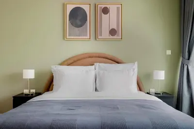 a bed with two lamps and two pictures on the wall at Blueground DIFC swimming pool gym security DXB-1545 in Dubai