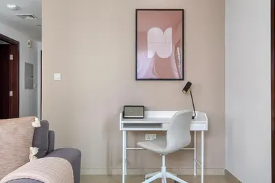 a white desk with a chair and a laptop on it at Blueground The Residences gym parking DXB-1348 in Dubai