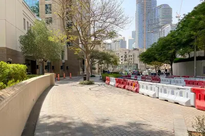 a sidewalk with red and white dividers in a city at Blueground The Residences gym parking DXB-1348 in Dubai