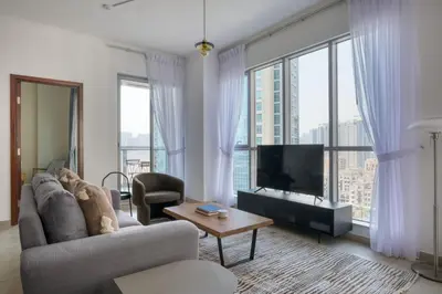 a living room with a couch and a tv at Blueground The Residences gym parking DXB-1348 in Dubai