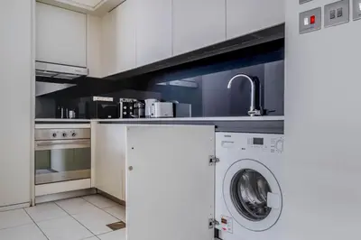a kitchen with a washing machine and a sink at Blueground DIFC Burj K views indoor pool DXB-1493 in Dubai