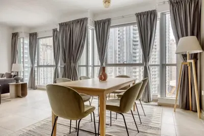 a dining room with a table and chairs and windows at Blueground Burj Residences BK view pool gym DXB-1131 in Dubai