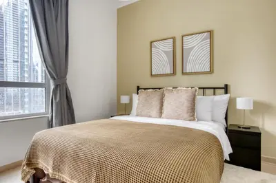 a bedroom with a large bed and a window at Blueground Burj Residences BK view pool gym DXB-1131 in Dubai