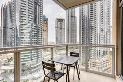 a table and two chairs on a balcony with city views at Blueground Burj Residences BK view pool gym DXB-1131 in Dubai