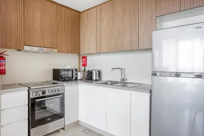 a kitchen with white cabinets and a stainless steel appliance at Blueground 5242 Tower sea view doorman pool DXB-867 in Dubai