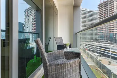 a balcony with two chairs and a table on a building at Waves - Executive Bay Studio, Canal View and Modern Amenities in Dubai