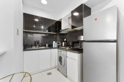 a kitchen with a refrigerator and a washing machine at Waves - Executive Bay Studio, Canal View and Modern Amenities in Dubai