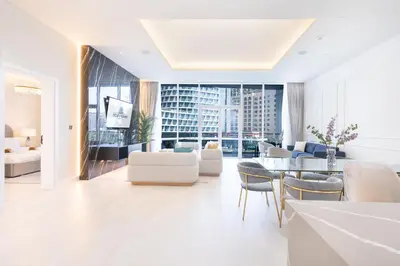 a living room with white furniture and a large window at Palm Home next to Nakheel Mall with Private Beach in Dubai