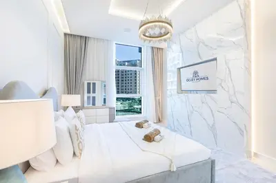 a white bedroom with a bed and a window at Palm Home next to Nakheel Mall with Private Beach in Dubai