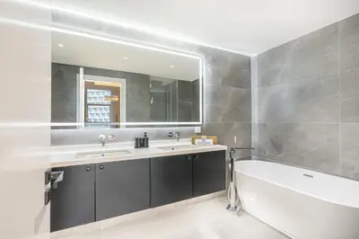 a bathroom with a tub and a sink and a mirror at Palm Home next to Nakheel Mall with Private Beach in Dubai