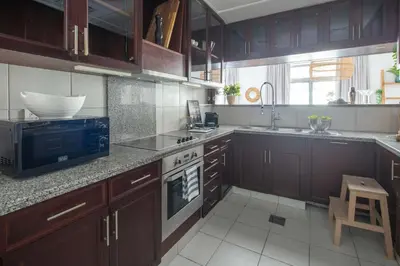 a kitchen with wooden cabinets and a stove top oven at Frank Porter - Arno A in Dubai