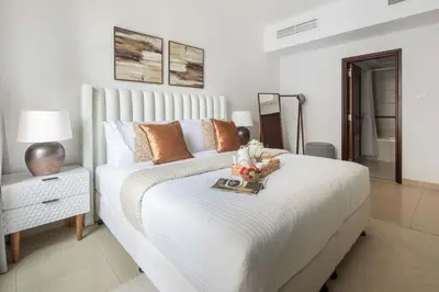 a bedroom with a large white bed with a tray on it at Frank Porter - Arno A in Dubai